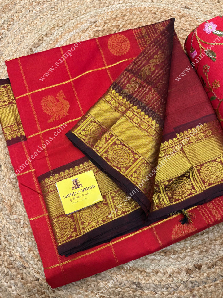 Bright Red with Arakku  , rich Zari checks in the body , Mayil and Chakram rich butta in the body , traditional border rich Pallu Silk Cotton Saree