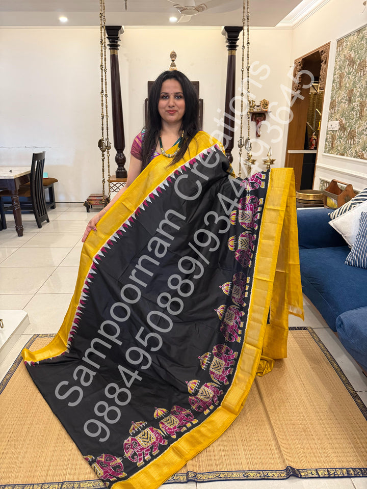 A traditional Black and Mustard combo with Majestic Elephants prints on one side border with traditional border and rich Pallu Pure Pochampally Silk Saree