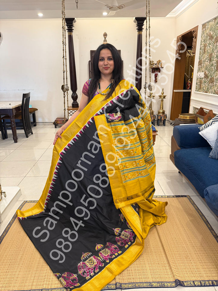 A traditional Black and Mustard combo with Majestic Elephants prints on one side border with traditional border and rich Pallu Pure Pochampally Silk Saree