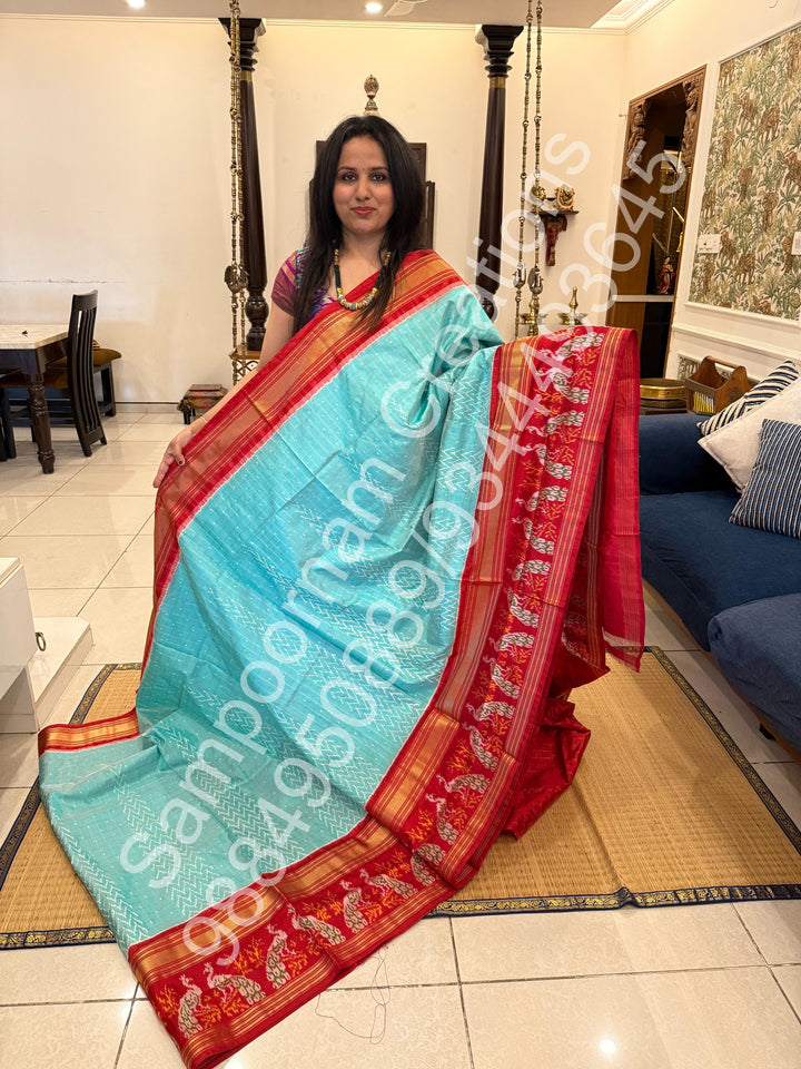 A Gorgeous Pastel Blue with Red saree , with rich Zari checks in the body and one side big Peacock design border and Grand Pallu Pure Pochampally Silk Saree