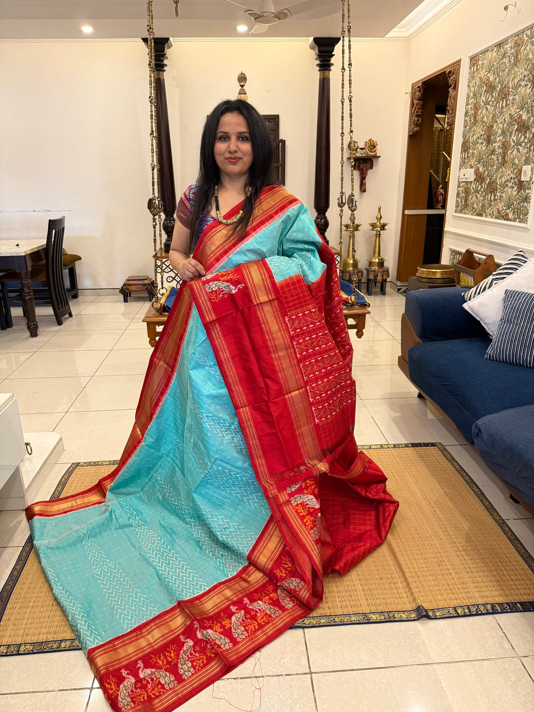 A Gorgeous Pastel Blue with Red saree , with rich Zari checks in the body and one side big Peacock design border and Grand Pallu Pure Pochampally Silk Saree