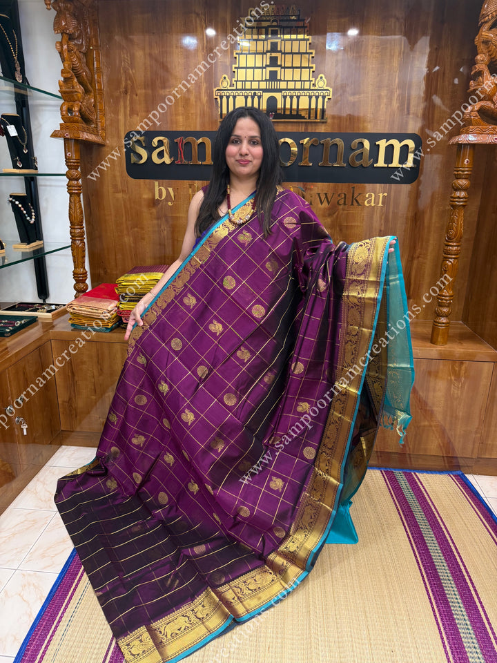 Wine with Turquoise Blue  , rich Zari checks in the body , Mayil and Chakram rich butta in the body , one side Long traditional border rich Pallu Silk Cotton Saree