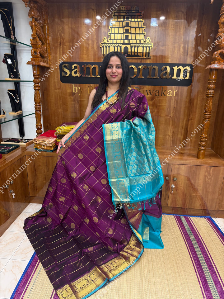 Wine with Turquoise Blue  , rich Zari checks in the body , Mayil and Chakram rich butta in the body , one side Long traditional border rich Pallu Silk Cotton Saree