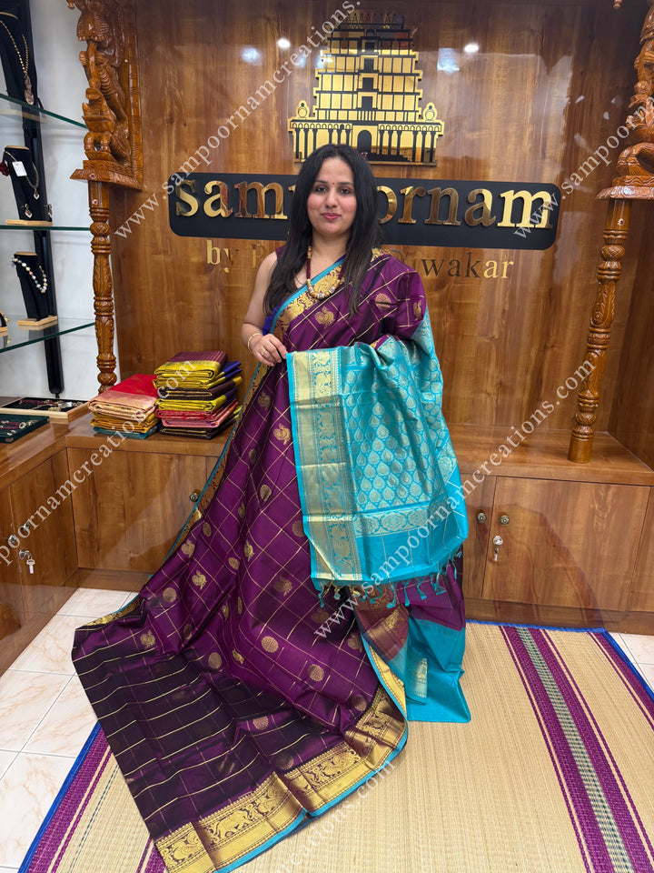 Wine with Turquoise Blue  , rich Zari checks in the body , Mayil and Chakram rich butta in the body , one side Long traditional border rich Pallu Silk Cotton Saree