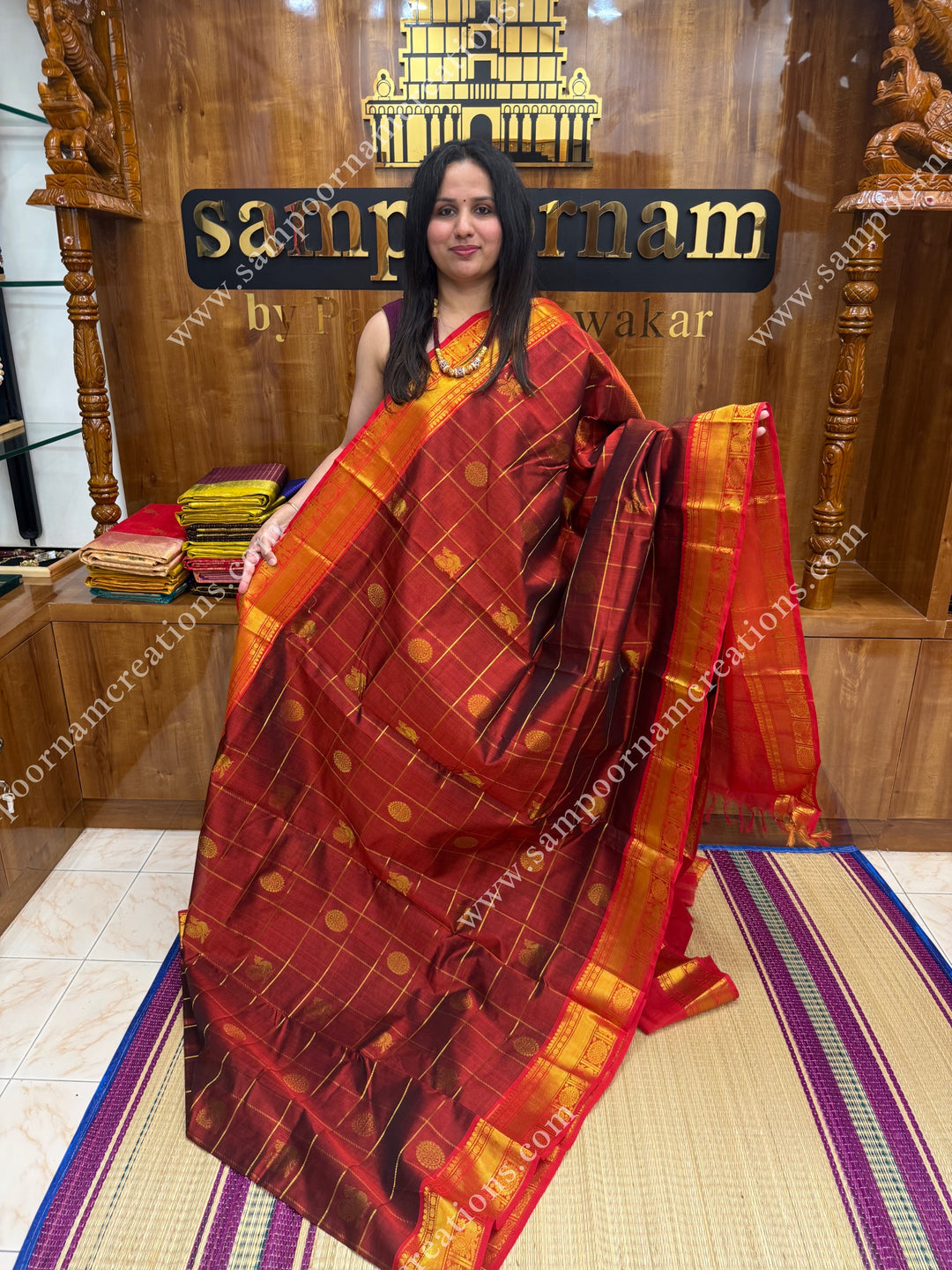 Arakku with Red  , rich Zari checks in the body , Mayil and Chakram rich butta in the body , traditional border rich Pallu Silk Cotton Saree