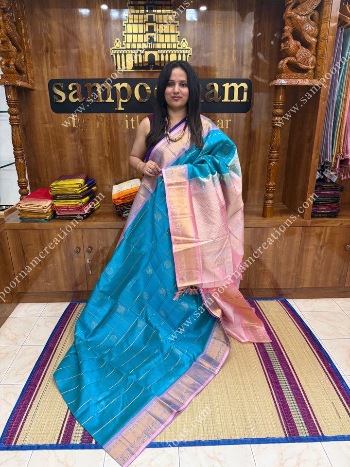 Turquoise Blue with Baby Pink  , rich Zari checks in the body , Mayil and Chakram rich butta in the body ,traditional border rich Pallu Silk Cotton Saree