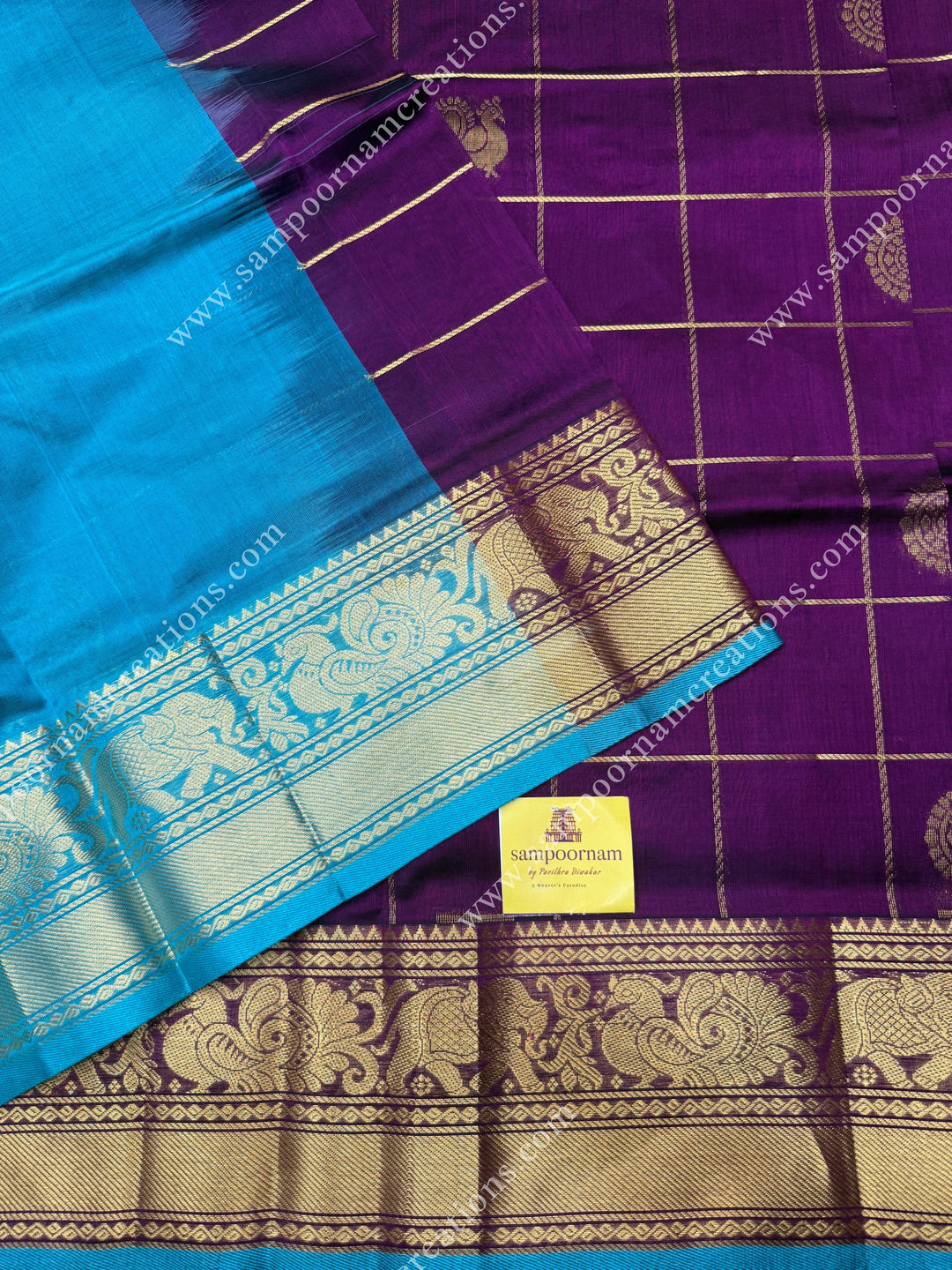 Wine with Turquoise Blue  , rich Zari checks in the body , Mayil and Chakram rich butta in the body , one side Long traditional border rich Pallu Silk Cotton Saree