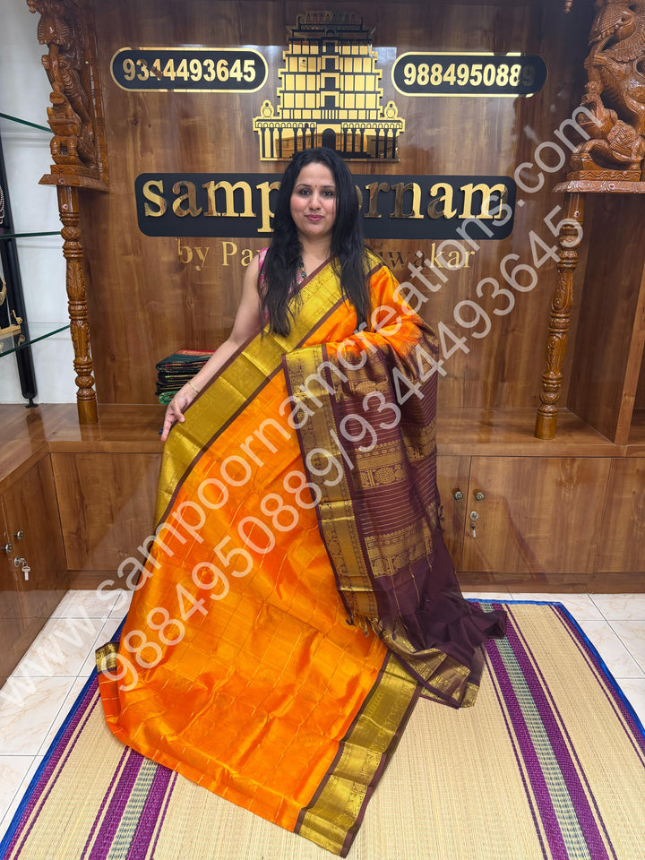 Orange with brown  , Rich Mayil and Chakram butta in the body with Zari Checks , Traditional borders and Rich Pallu Pure Silk Cotton Saree