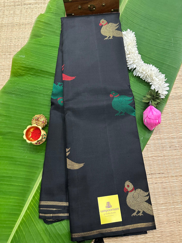 A Classic Black Saree with Kalakshetra Kili Butta in the body and Palla , with green and red thread work and gold Zari work, Rich Pallu Pure Kanjivaram Silk Saree