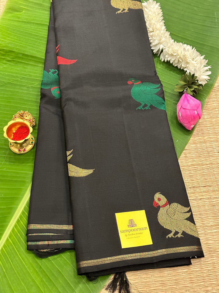 A Classic Black Saree with Kalakshetra Kili Butta in the body and Palla , with green and red thread work and gold Zari work, Rich Pallu Pure Kanjivaram Silk Saree