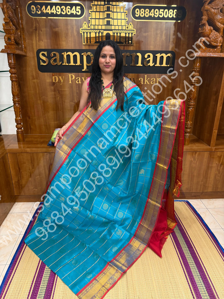Ramar Blue with Red  , Rich Mayil and Chakram butta in the body with Zari Checks , Traditional borders and Rich Pallu Pure Silk Cotton Saree