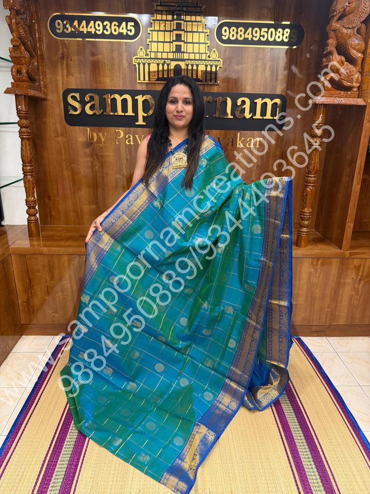 Double Shaded Teel Blue with Blue  , Rich Mayil and Chakram butta in the body with Zari Checks , Traditional borders and Rich Pallu Pure Silk Cotton Saree