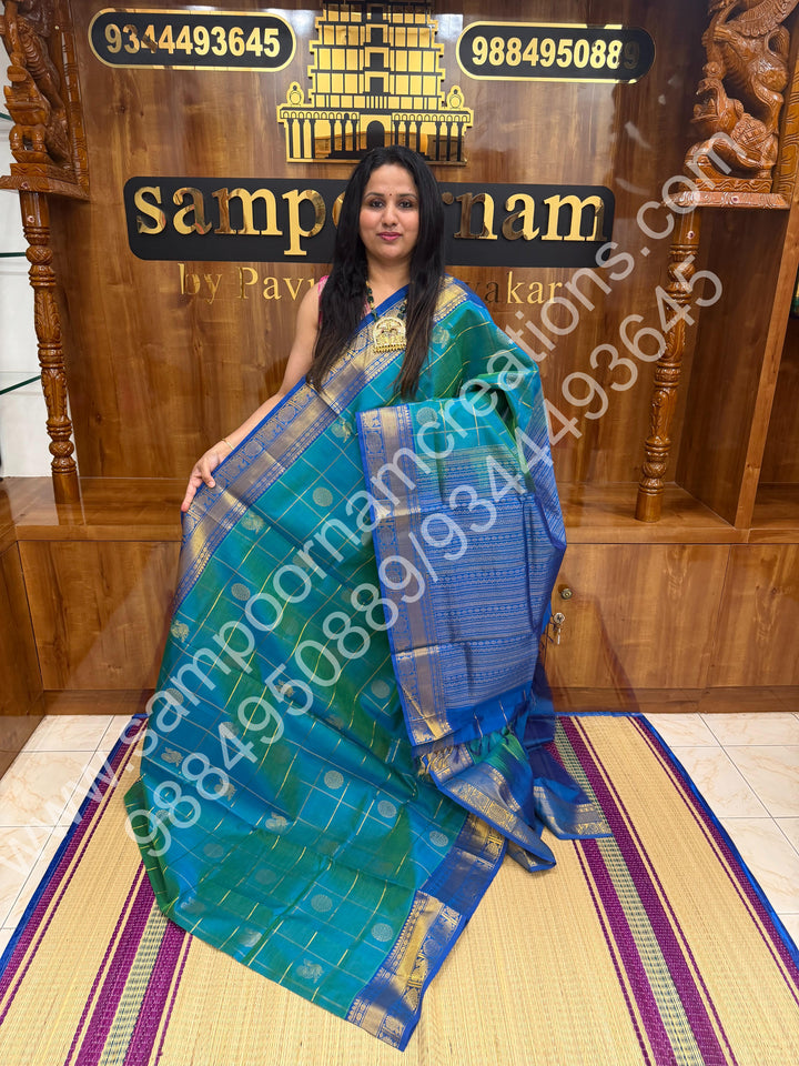 Double Shaded Teel Blue with Blue  , Rich Mayil and Chakram butta in the body with Zari Checks , Traditional borders and Rich Pallu Pure Silk Cotton Saree