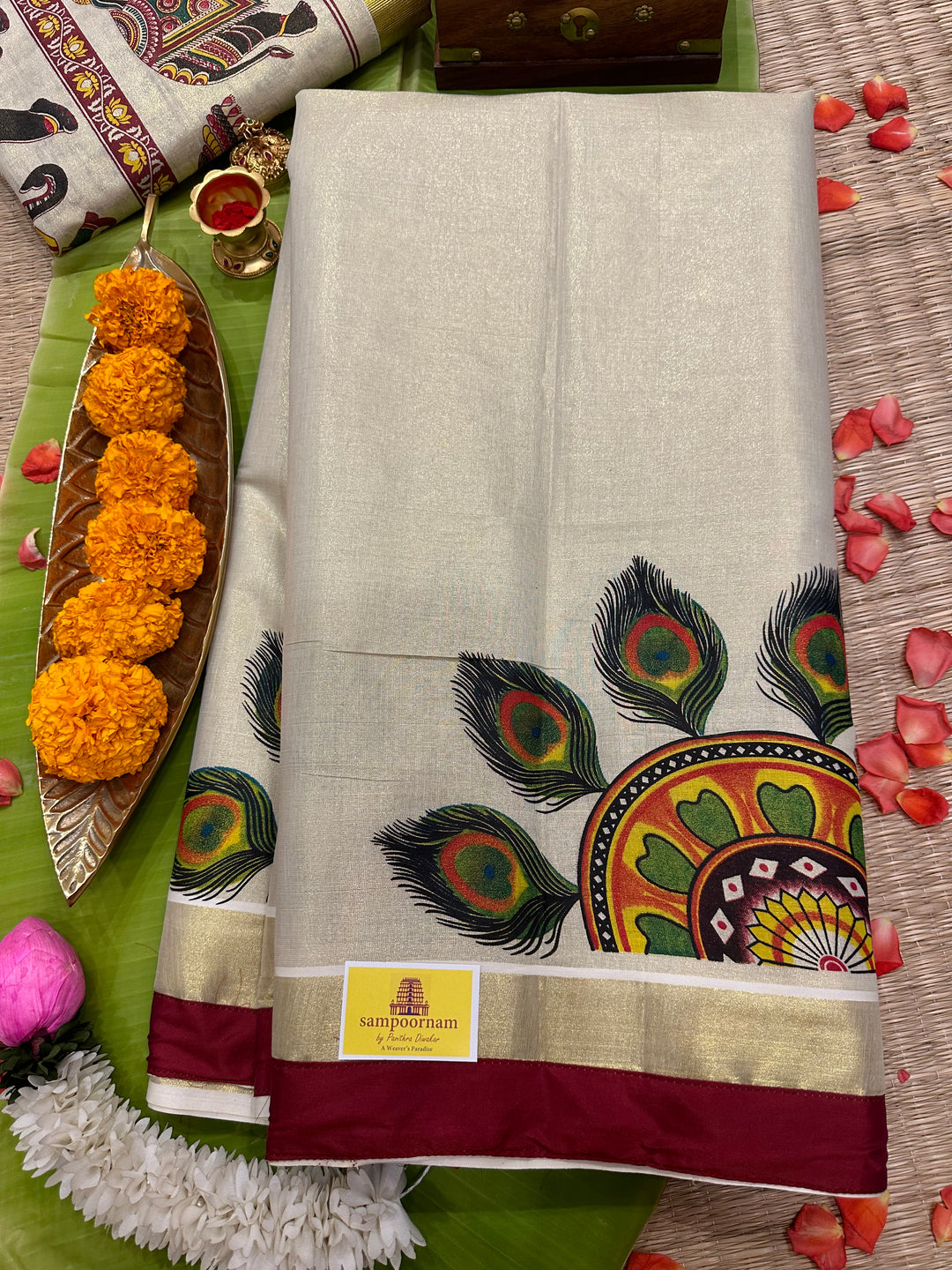 Kerala Tissue Saree with Peackock Feather Rangoli Motif and Maroon Piping in Borders