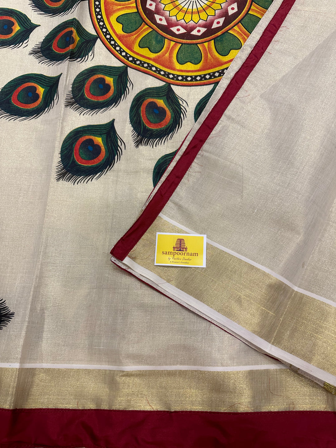 Kerala Tissue Saree with Peackock Feather Rangoli Motif and Maroon Piping in Borders