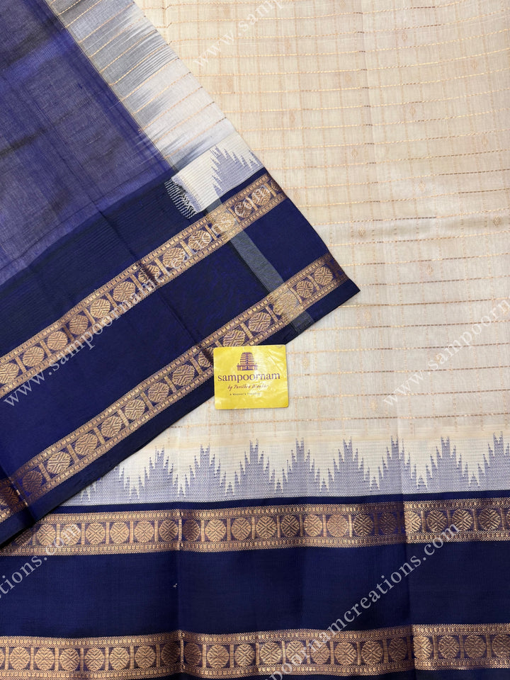 Offwhite with Dark Blue  , Rich Zari checks and Butta in the body and  rettapet  borders , rich Pallu Korvai Silk Cotton Sareee