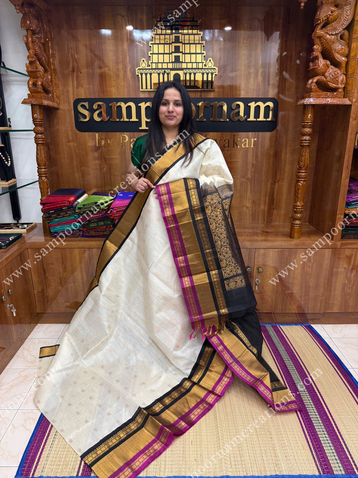 Offwhite with Black , Rich Floral Zari butta in the body and Oneside Triple  borders , rich Pallu Korvai Silk Cotton Sareee