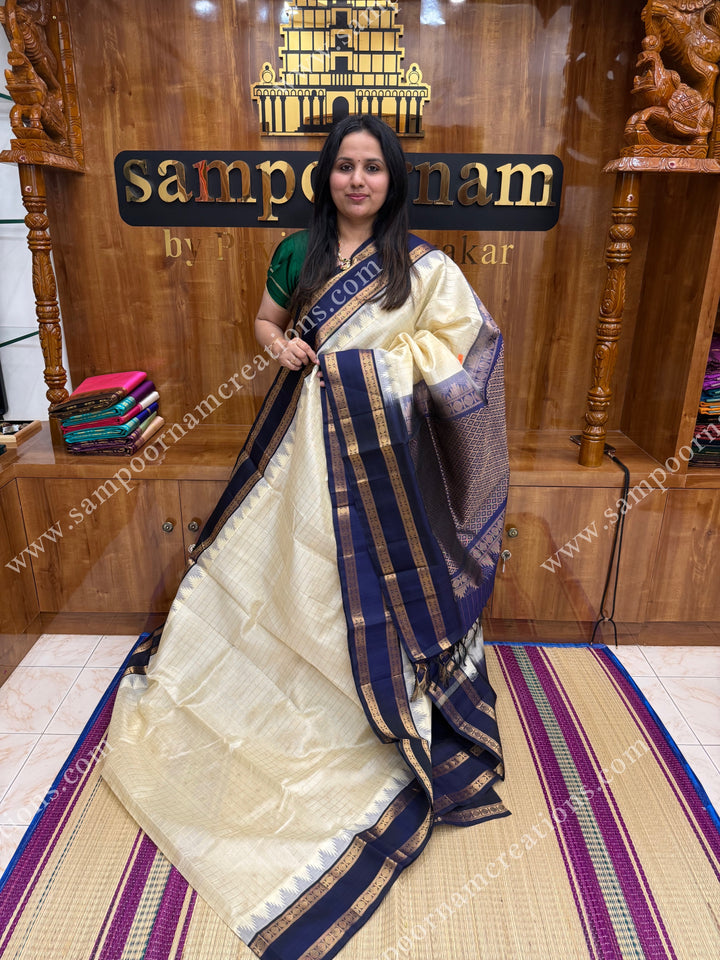 Offwhite with Dark Blue  , Rich Zari checks and Butta in the body and  rettapet  borders , rich Pallu Korvai Silk Cotton Sareee