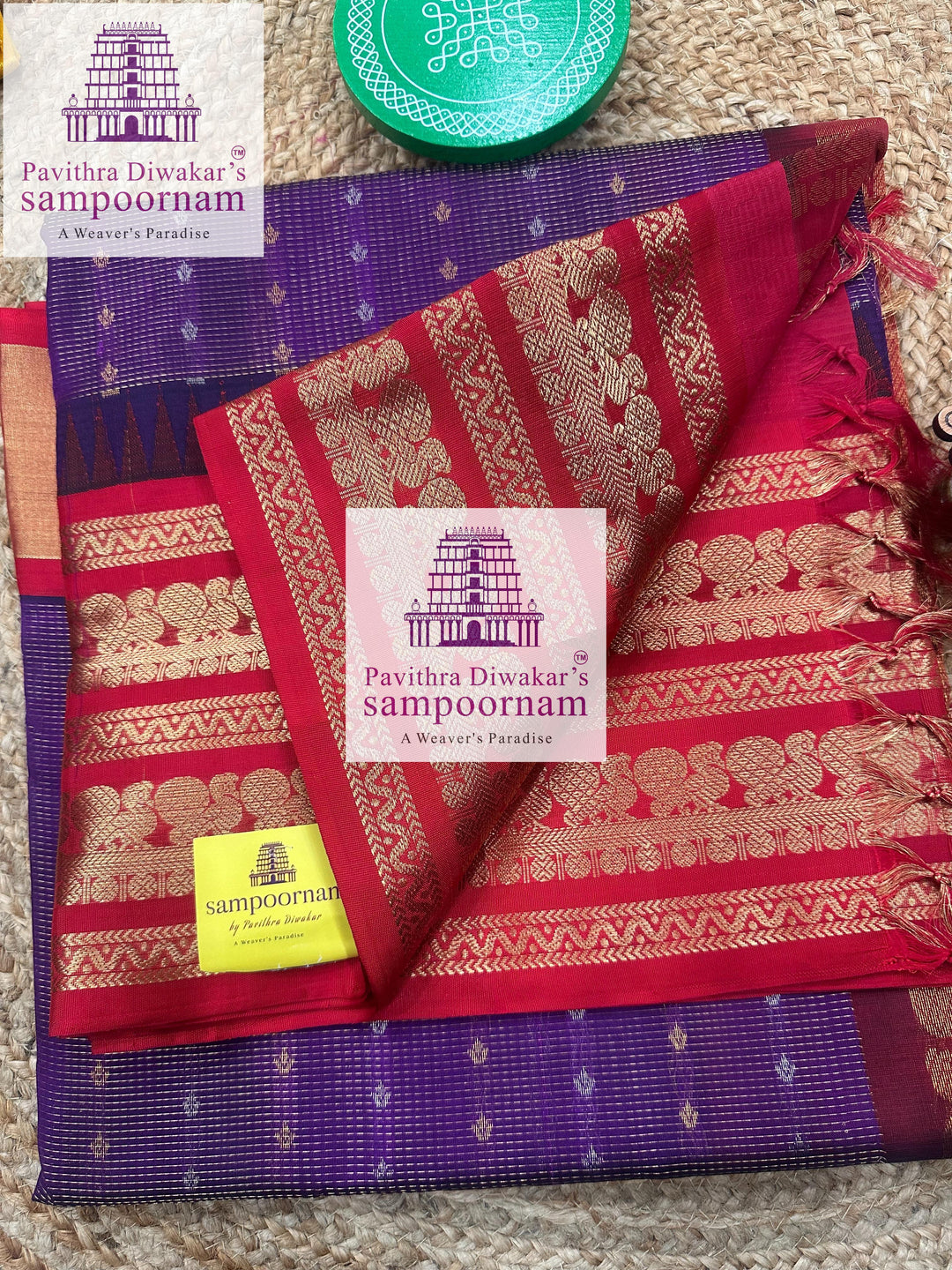 Deep Purple with Red , one side rich Kanchi border , rich Zari checks in the body with Zari butta in Silver and Gold Zari , grand Pallu Silk Cotton Saree