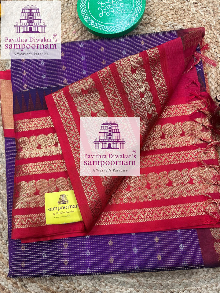 Deep Purple with Red , one side rich Kanchi border , rich Zari checks in the body with Zari butta in Silver and Gold Zari , grand Pallu Silk Cotton Saree