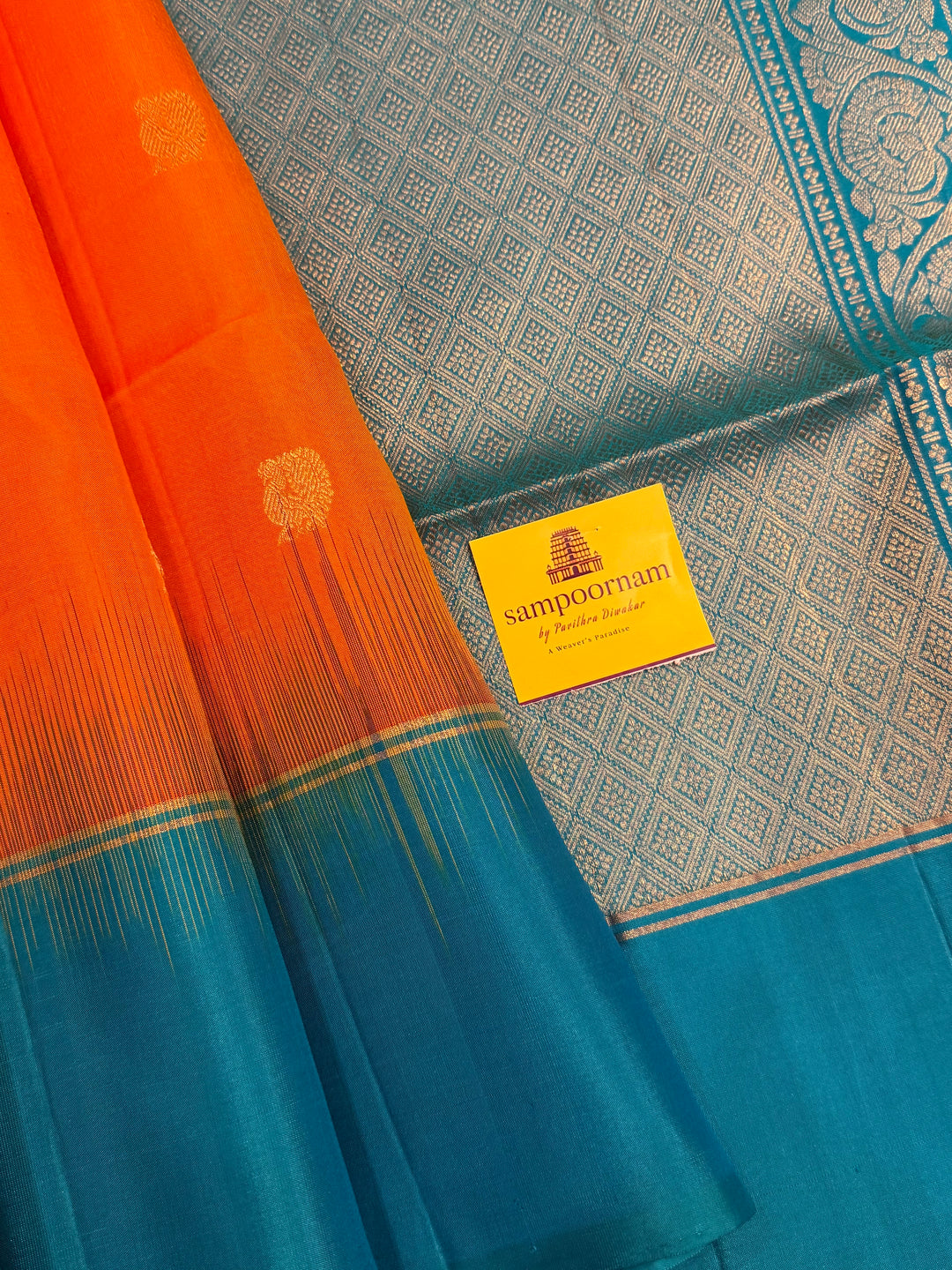 Fanta Orange with Turquoise Blue, rich zari butta in the body and an elaborate rich Pallu Pure Soft Silk Saree
