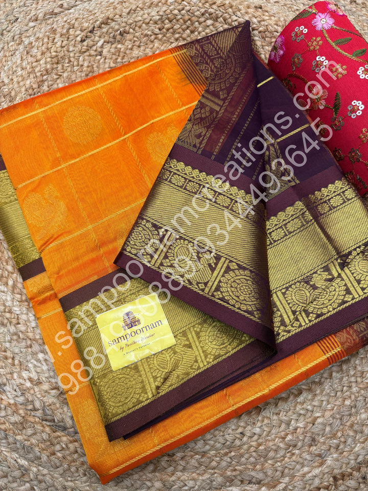 Orange with brown  , Rich Mayil and Chakram butta in the body with Zari Checks , Traditional borders and Rich Pallu Pure Silk Cotton Saree