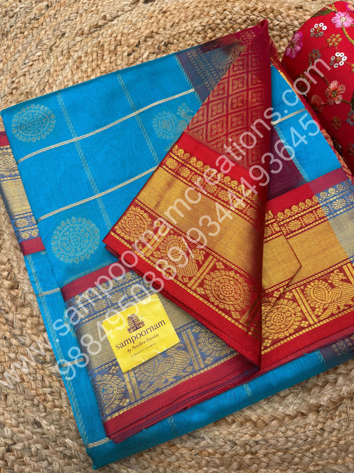 Ramar Blue with Red  , Rich Mayil and Chakram butta in the body with Zari Checks , Traditional borders and Rich Pallu Pure Silk Cotton Saree