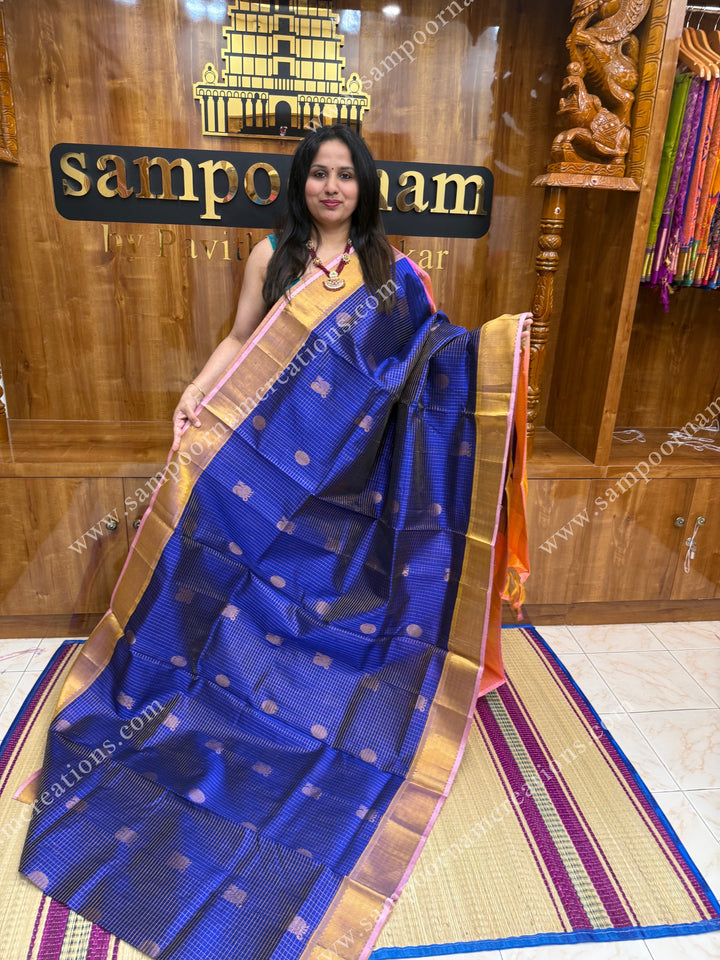 Blue with Baby Pink  , rich Zari checks and Mayil Chakram rich butta in the body , traditional border and  rich Pallu Silk Cotton Saree