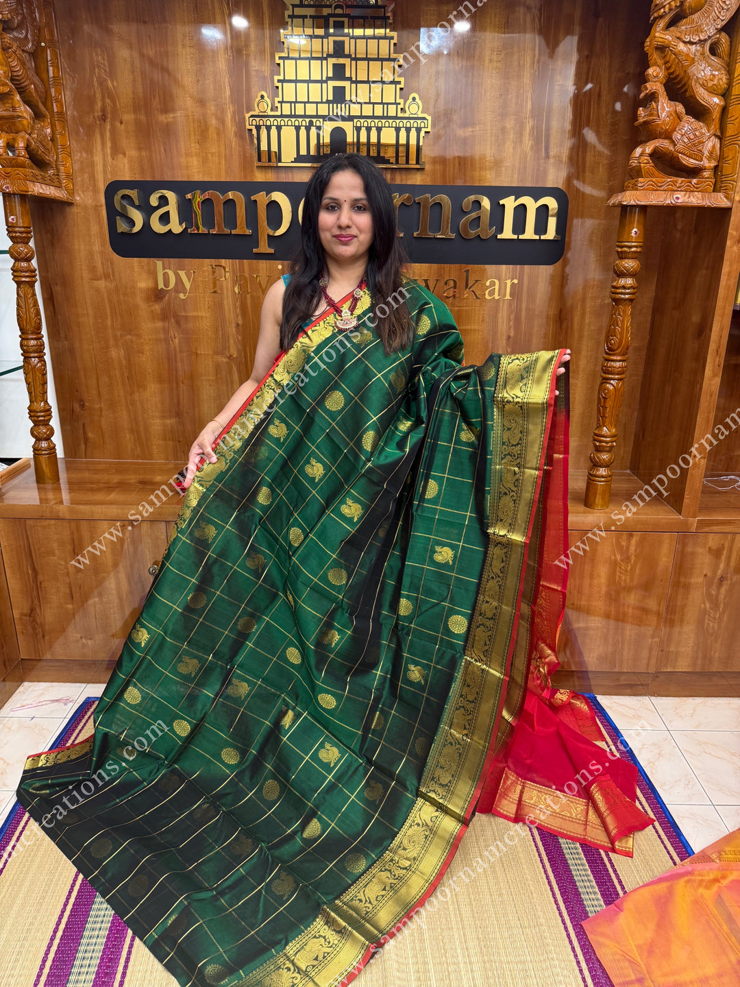 Green with Red , rich Zari checks in with Mayil and Chakram rich butta in the body , one side long traditional border and rich Pallu Silk Cotton Saree