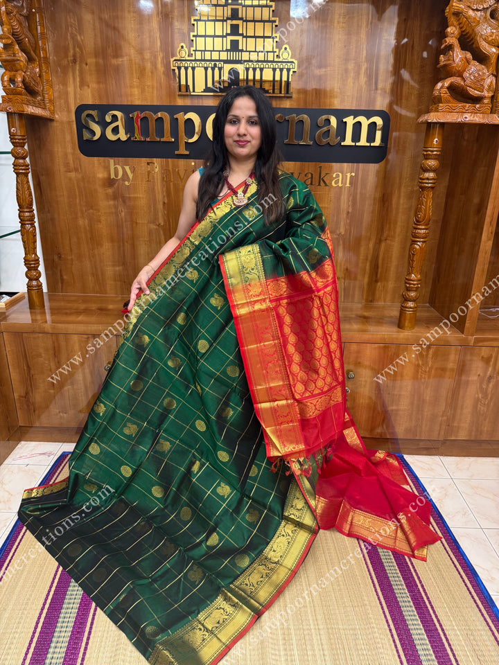 Green with Red , rich Zari checks in with Mayil and Chakram rich butta in the body , one side long traditional border and rich Pallu Silk Cotton Saree