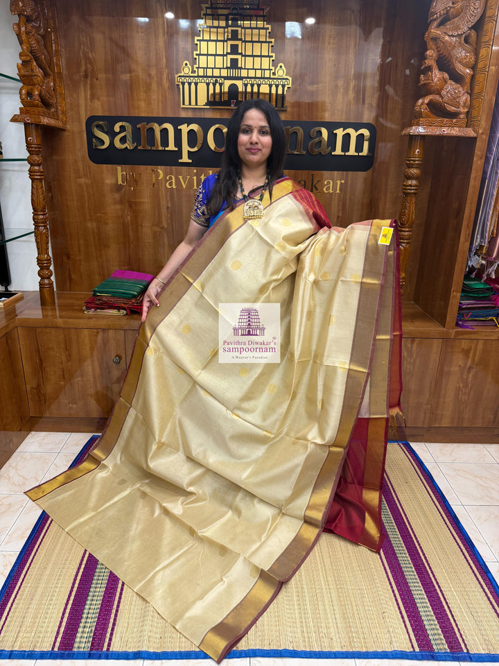 Light Gold with Red , rich Zari butta in the body , traditional border and traditional border and Rich Pallu Silk Cotton Saree