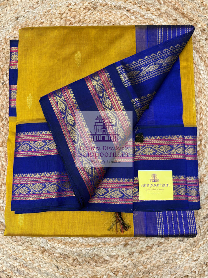 Dark Gold with Dark Blue , Zari butta in the body , rettapet borders and Zari checks in the body , rich Pallu Korvai Silk Cotton Saree