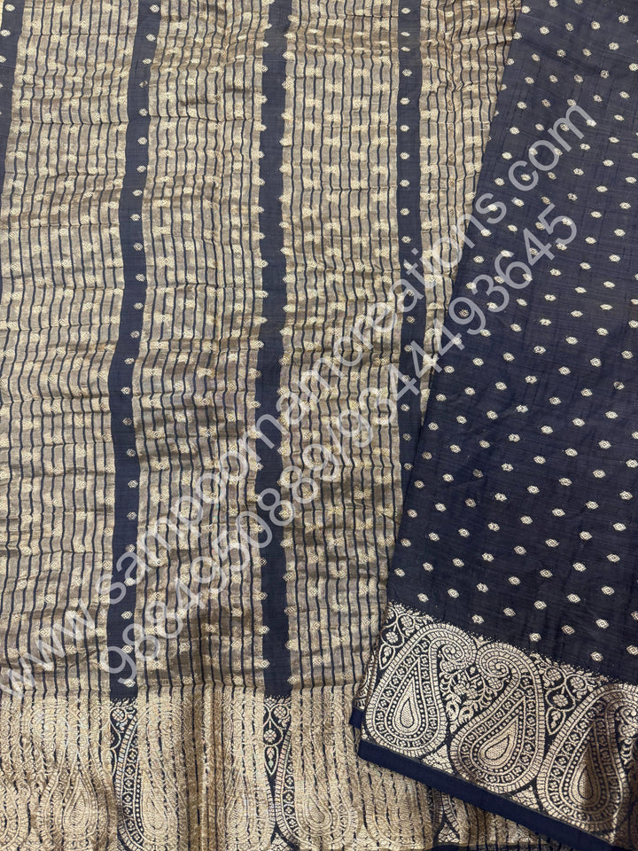 Black with Zari Buttas all over the body , Traditional rich Mango designs in the border and Tissue Pallu , Semi Tussar Saree