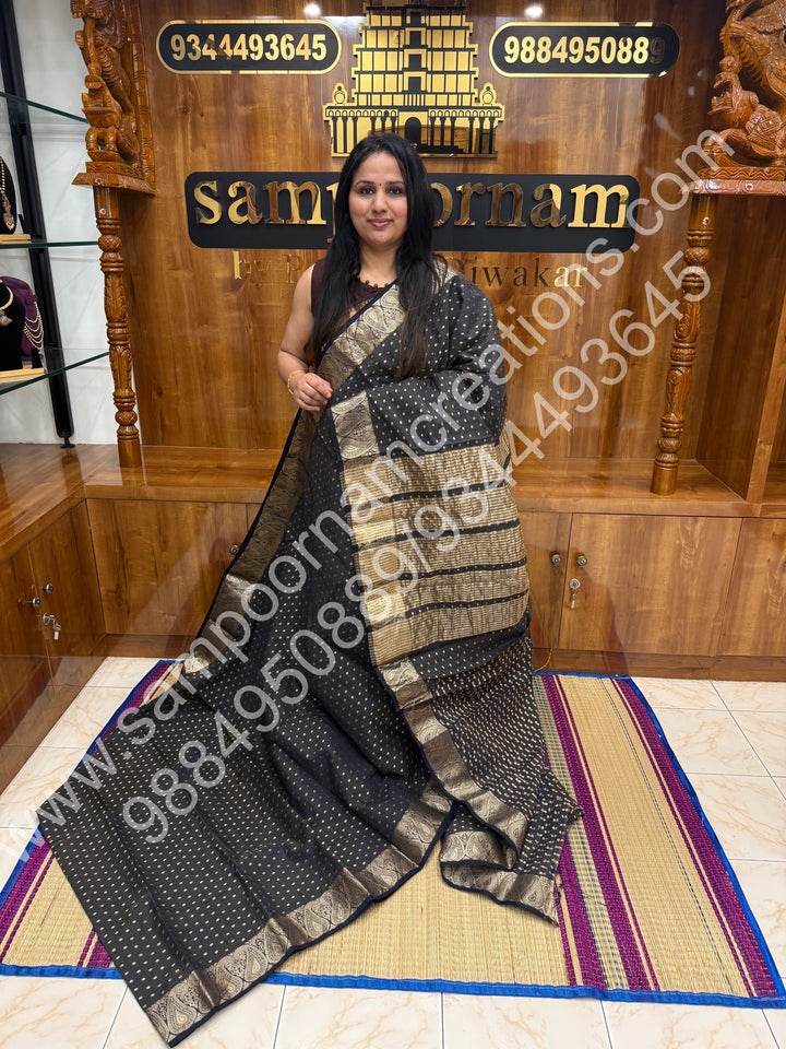 Black with Zari Buttas all over the body , Traditional rich Mango designs in the border and Tissue Pallu , Semi Tussar Saree