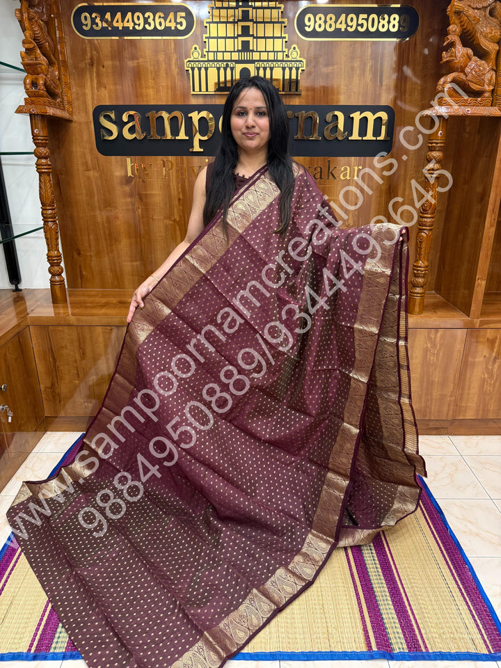 Burgundy with Zari Buttas all over the body , Traditional rich Mango designs in the border and Tissue Pallu , Semi Tussar Saree
