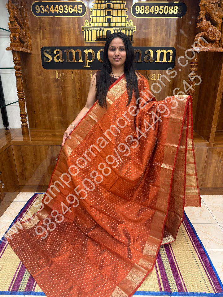 Rust Orange with Zari Buttas all over the body , Traditional rich Mango designs in the border and Tissue Pallu , Semi Tussar Saree