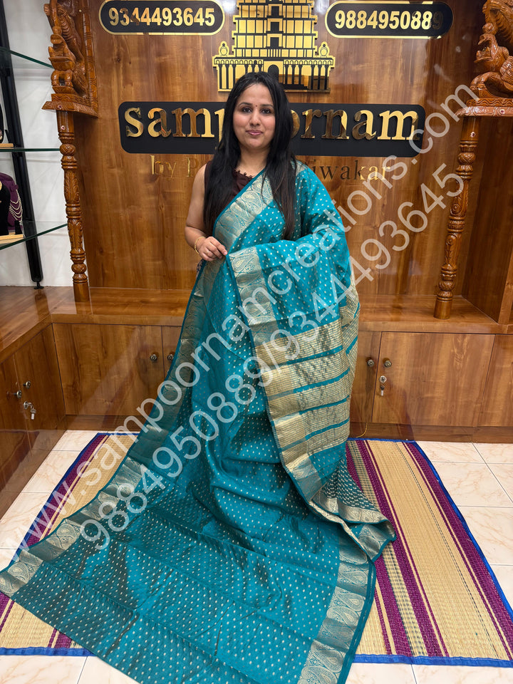 Turquoise Blue with Zari Buttas all over the body , Traditional rich Mango designs in the border and Tissue Pallu , Semi Tussar Saree